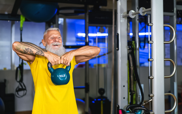 persona mayor practicando remo al cuello con una kettlebell