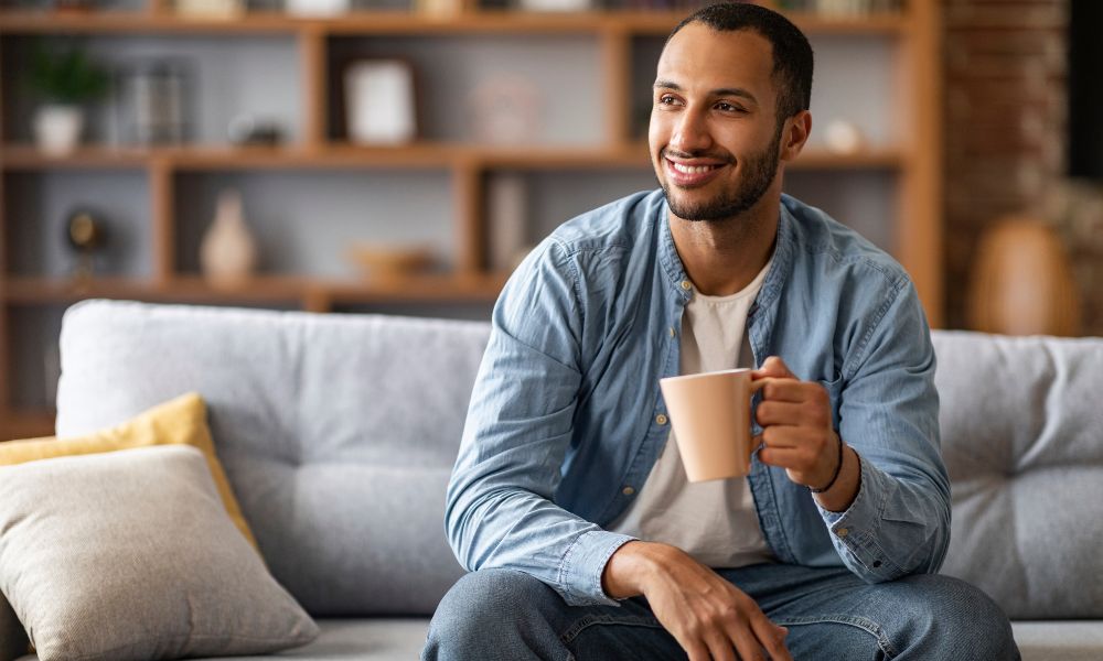 homme avec une tasse de cafe chez lui