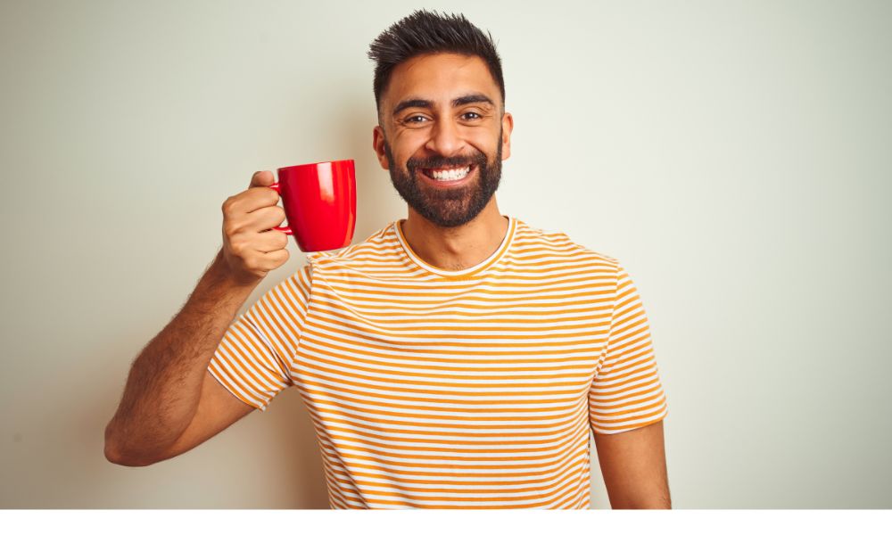 homme tennat une tasse de cafe